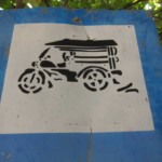 Panneau de signalisation routière avec un tuk tuk dessiné au pochoir